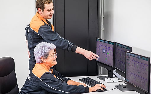 двама работници гледат към компютърен монитор
